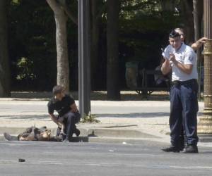 La policía logró extraer del vehículo el cuerpo del sospechoso, quien después yacía en el suelo cubierto con una sábana blanca. (Foto: AP/ El Heraldo Honduras/ Noticias de Honduras)