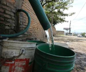 Algunos pobladores han tenido que acudir a comprar agua de pozo ante la falta de agua en sus hogares. Foto: Jimmy Argueta/ EL HERALDO