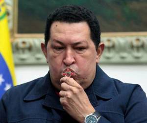 (FILE) Handout picture released by the Venezuelan Presidency showing Venezuela's President Hugo Chavez kissing a crucifix as he sits with ministers during a televised radio interview in Caracas on 8 December, 2012 where he announced he should head back to Cuba to undergo new cancer surgery. February 10, 2013 marks two months since Chavez's last public appearance, when he left for Cuba. Chavez underwent his fourth round of cancer surgery in Havana on December 11, and since then has neither been seen nor heard. AFP PHOTO/PRESIDENCIA --- RESTRICTED TO EDITORIAL USE - MANDATORY CREDIT 'AFP PHOTO/PRESDIENCIA' - NO MARKETING NO ADVERTISING CAMPAIGNS - DISTRIBUTED AS A SERVICE TO CLIENTS
