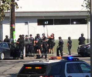 Decenas de oficiales permanecen afuera del supermercado.