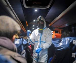 Hospital employees wearing a protection mask and gear tend to a patient (C) at a temporary emergency structure set up outside the accident and emergency department, where any new arrivals presenting suspect new coronavirus symptoms are being tested, at the Brescia hospital, Lombardy, on March 13, 2020. (Photo by Miguel MEDINA / AFP)