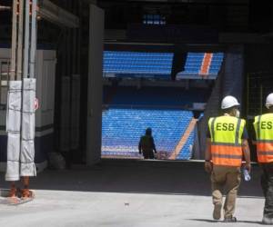 Un par de trabajadores se dirige al estadio Santiago Bernabéu, sede del club Real Madrid en Madrid, España. Foto: AP.
