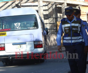 Dos agentes policiales custodian la escena; al fondo el bus varado con las dos víctimas en su interior.