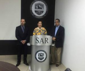 La directora del SAR, Miriam Guzmán, se dirige a los medios acompañada de Santiago Herrera y Gustavo Solórzano del Cohep.