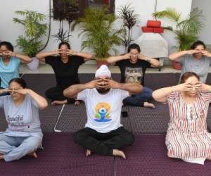 Grupos de personas hacen ejercicios de yoga en casa, atendiendo el llamado del primer ministro. AFP.