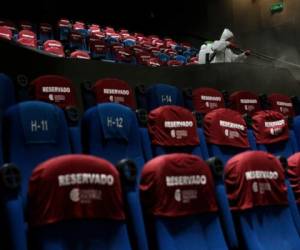 Un trabajador desinfecta una sala de cine tras una función en la Cineteca Nacional en la Ciudad de México el miércoles 12 de agosto de 2020. Después de estar cerrados casi cinco meses los cines reabrieron en la capital a 30% de capacidad.