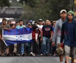 Muchos portan banderas de Honduras y otros empujan los carritos de sus niños pequeños.