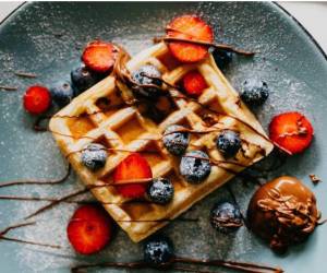 Esta preparación se caracteriza por su masa suave y su inconfundible forma cuadriculada, que se consigue al cocinarla en una wafflera.