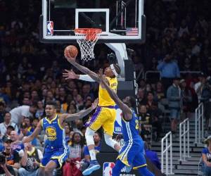 Michael Beasley, el número 11 de los Lakers de Los Ángeles, busca una bandeja sobre Draymond Green, número 23 y Jacob Evans, el número 10 de los Golden State Warriors durante la segunda mitad de su partido de baloncesto de pretemporada de la NBA en el SAP Center el 12 de octubre de 2018 en San José, California. (AFP)