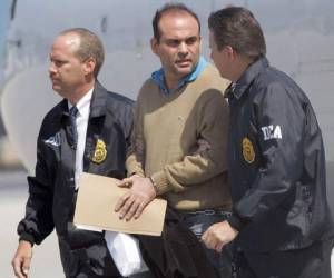 El jefe paramilitar colombiano Salvatore Mancuso es acompañado por dos agentes federales en su llegada a Opa-locka, Florida, después de ser deportado por Colombia, el 13 de mayo de 2008. (AP Foto/Alan Diaz, Archivo)