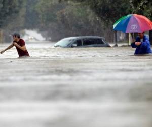 Moses Juarez, left, and Anselmo Padilla wade through floodwaters from Tropical Storm Harvey on Sunday, Aug. 27, 2017, in Houston, Texas. (AP Photo/David J. Phillip)