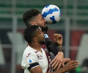 El francés Olivier Giroud (2do plano) remata de cabeza junto a Gelison Bremer, del Torino, durante un partido de la Serie A italiana. (AP Foto/Luca Bruno)