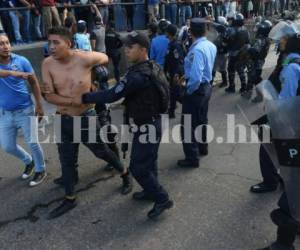 Momento en que elementos policiales llevan detenidos a varios jóvenes que se enfrentaron en las afueras del Estadio Nacional de Tegucigalpa. Fotos: El Heraldo.