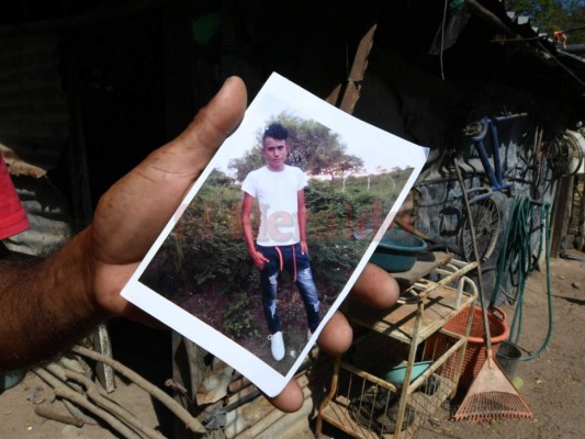 El campesino hondureño Wilfredo Cruz, padre de los migrantes Luz Marina Cruz y Oscar Cruz, muestra la imagen del Oscar, quien murió en un accidente a pocos kilómetros de Tijuana, México. Foto Agencia AFP.