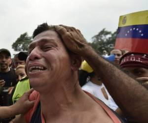 Un hombre venezolano reacciona al despedirse de un pariente, un miembro de las Fuerzas Armadas Bolivarianas (FANB) de Venezuela, mientras es escoltada por agentes de la policía colombiana después de desertar, cerca del puente internacional Simón Bolívar en Cúcuta, Colombia. Fotos Agencia AFP