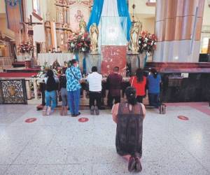 Los feligreses se postran ante la imagen sagrada de la Virgen de Suyapa. Andrés Gómez, de camisa color vino, se mantuvo arrodillado por más de 15 minutos ante la Patrona de Honduras.