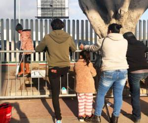 Varias personas que buscan solicitar asilo en Estados Unidos esperan en un puente fronterizo de Tijuana, México. Foto: AP.
