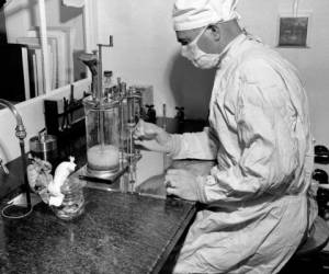 Esta fotografía de archivo del 2 de diciembre de 1947 muestra a Charles D. Brown mientras llena un recipiente con la vacuna BCG contra la tuberculosis, en un laboratorio estatal en Albany, Nueva York. (AP Foto)
