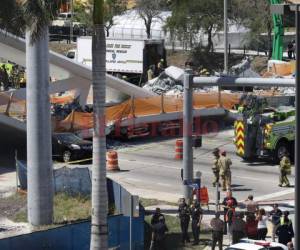El personal del Departamento de Bomberos de Miami-Dade y otras unidades de rescate trabajan en la escena en la que un puente peatonal se derrumbó unos días después de que se construyera sobre la calle 8 suroeste, permitiendo a la gente eludir la concurrida calle para llegar a la Universidad Internacional de Florida. Foto AFP