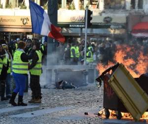 Los protestantes denominados 'chalecos amarillos' mantienen su marcha en París. (AFP)