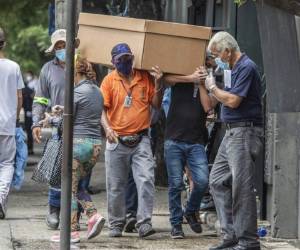 Trabajadores de un cementerio cargan los restos de una persona en un ataÃºd de cartÃ³n en el Cementerio General en Guayaquil, Ecuador, el lune s 6 de abril de 2020. (AP Foto/Luis Perez)