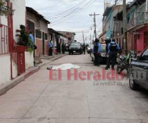 Luego del hecho vecinos salieron a ver el cadáver del joven y lo taparon con una sábana blanca. Foto: Alex Pérez / EL HERALDO.