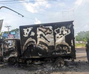 Una camioneta quemada permanece en un cruce vial, un día después de tiroteos entre presuntos miembros del cártel de Sinaloa y fuerzas de seguridad en Culiacán. Foto: AP.