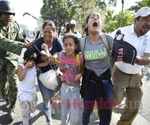 A empujones y gritos la Guardia Nacional de México repelió a cientos de centroamericanos, en su mayoría hondureños, que entraron al país azteca la mañana de este jueves. Fotos: AFP.