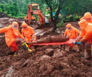 La Fuerza Nacional de Respuesta a Desastres (NDRF) muestra a personal de emergencias recuperando el cuerpo de una víctima de un alud de tierra en Ratnagiri, en la región occidental india de Maharashtra, este domingo. FOTO: AP
