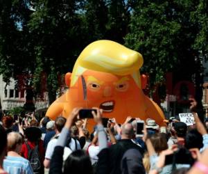 Para burlarse de Donald Trump, los manifestantes lanzaron al cielo un globo gigante que lo representa como un bebé gritón anaranjado. Foto AP