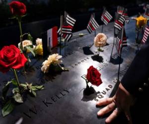 Un bombero coloca su mano sobre los nombres tallados en el ala sur durante las ceremonias para conmemorar el 20mo aniversrio de los ataques terroristas del 11 de septiembre, el 11 de septiembre de 2021, en el Museo Nacional del 11 de Septiembre, en Nueva York. (AP Foto/John Minchillo, Archivo).