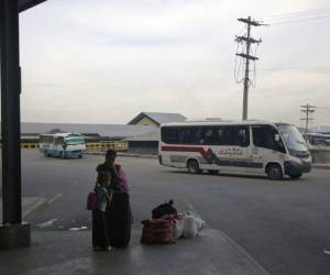 Por las noches, docenas de personas duermen en el suelo o en el césped. Algunas esperan el autobús que las llevará a la frontera con Guatemala. Foto: AP