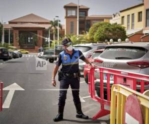 Un policía español bloquea el acceso al hotel H10 Costa Adeje Palace en la isla de Tenerife, España. Foto: AP.