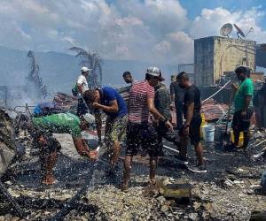 Los lugareños se refrescan luego de un incendio en la isla de Guanaja, en las turísticas Islas de la Bahía, Honduras. Foto: AFP