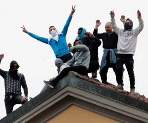 El lunes, los reclusos alzados treparon hasta el techo de la Prisión San Vittore en Milán y alzaron un cartel que decía “Indulto”. AP.