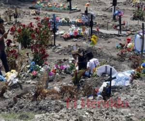 Una familia corona a un difunto en el cementerio Jardín de Los Ángeles. Foto: David Romero/El Heraldo