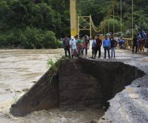 La gente observa los daños causados ​​por las fuertes lluvias provocadas por el huracán Eta, ahora degradado a tormenta tropical, en un puente sobre el río Cahaboncito inundado en Panzos, Alta Verapaz, 220 km al norte de la ciudad de Guatemala . Foto: AFP.