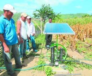 Con apoyo del panel solar, los campesinos hacen mover el sistema de riego.