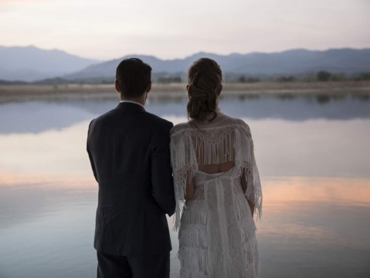 María Fernanda Vera y Juan José Pocaterra ven caer el sol sobre un lago después de casarse en una hacienda de Acarigua, Venezuela, el 16 de febrero del 2019. (AP Photo/Rodrigo Abd).