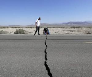 Ron Mikulaco, derecha, y su sobrino Brad Fernandez examinan una grieta causada por un sismo sobre la carretera 178 el sÃ¡bado 6 de julio de 2019, en las afueras de Ridgecrest, California. (AP Foto/Marcio Jose Sanchez)