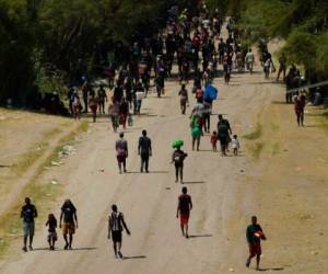 Migrantes haitianos caminan por un camino de tierra después de ingresar a Estados Unidos desde México, el viernes 17 de septiembre de 2021, en Del Rio, Texas. Foto: AP