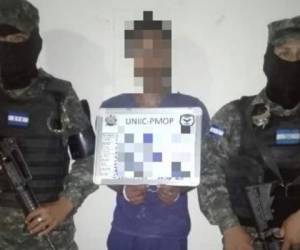 El detenido Donald Nahún Padilla Montes posa junto a dos elementos de la Policía Militar del Orden Público (PMOP).