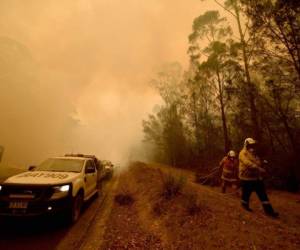 Los bomberos abordan desde hace semanas el incendio forestal con humo espeso en la ciudad de Moruya, al sur de Batemans Bay, en Nueva Gales del Sur. AFP.