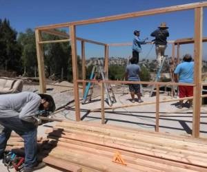 Los propios migrantes mientras levantan un anexo a la casa refugio El Puente.