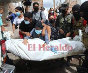Momento en que el cuerpo del joven era trasladado hasta el vehículo de Medicina Forense. Foto: Estalin Irías | EL HERALDO.