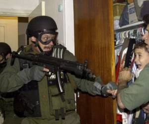 La emblemática fotografía de Díaz muestra a un agente de inmigración de Estados Unidos frente a un niño en la casa de la Pequeña Habana de Miami en donde vivía con sus parientes después de que lo encontraron flotando en la costa de Florida. (AP)