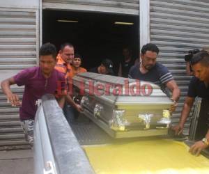 Familiares de Jeferson Gutiérrez sacan el ataúd de la morgue. Foto: Stalin Irías/EL HERALDO