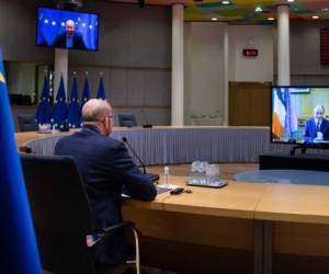 El presidente del Consejo Europeo, Charles Michel, habla con el primer ministro irlandés Micheal Martin, en pantalla a la derecha, por videoconferencia en la sede del consejo, Bruselas, sobre la inmunización mundial. (AP Foto/Olivier Matthys, Pool)