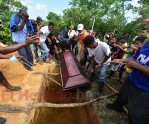 Los familiares colocan el ataúd con los restos de una de las víctimas de un accidente de barco en una tumba en la aldea Prumitara, cerca de Puerto Lempira, Honduras. Foto: Orlando Sierra/EL HERALDO.