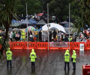 La policía se para bajo la lluvia mientras protege el Parlamento en el quinto día de manifestaciones contra las restricciones de Covid-19 en Wellington el 12 de febrero de 2022, inspirado en una manifestación similar en Canadá.
